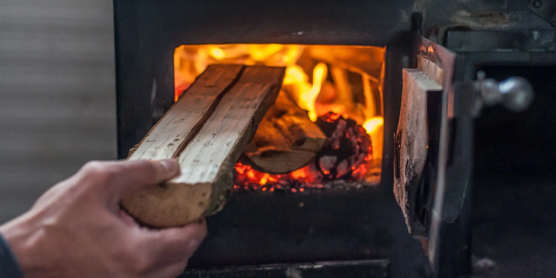 Putting log into fire stove